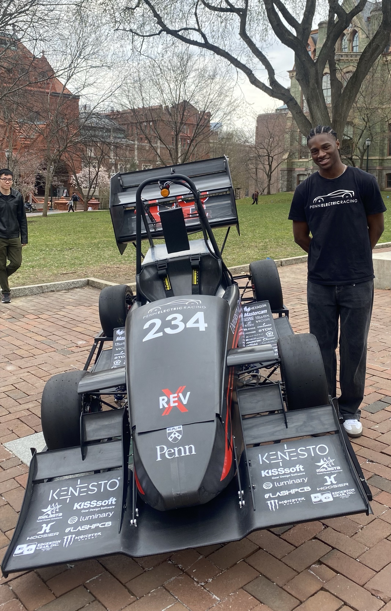 Derek Ike beside the finished Penn Electric Racing Formula SAE car at its unveiling on campus