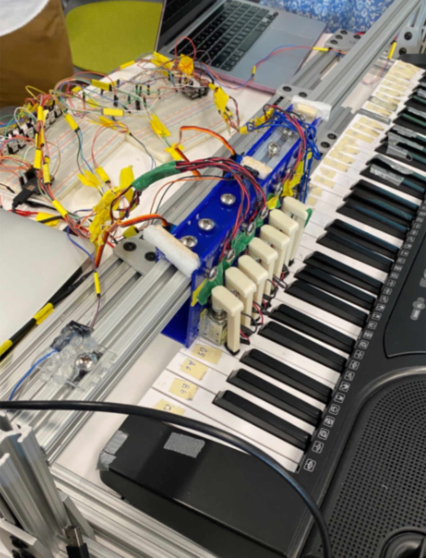 Solenoid and rack-and-pinion mechanism over a piano keyboard